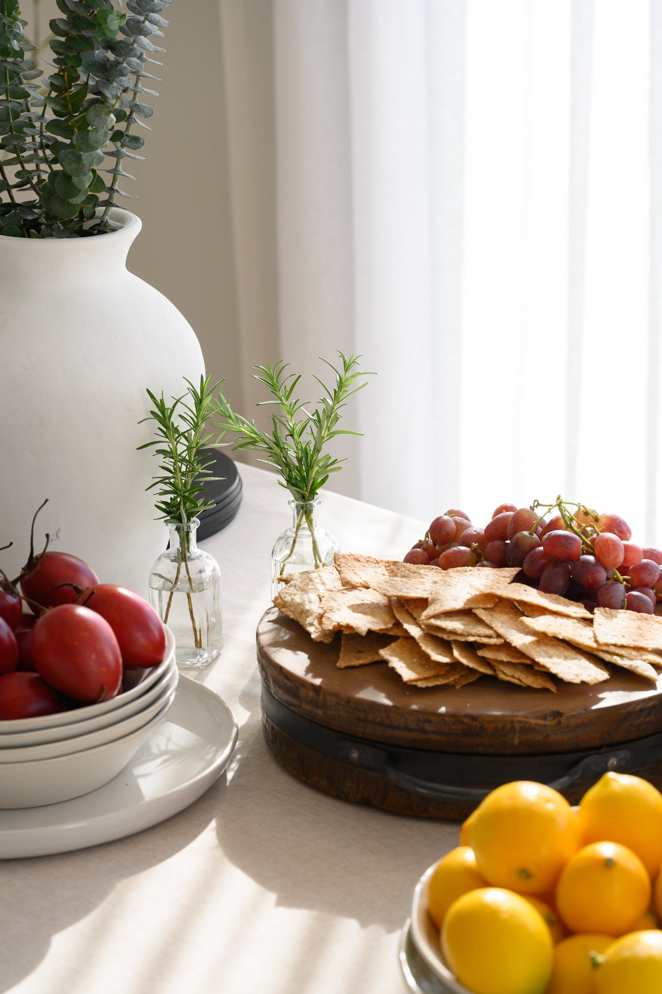 Dining table styled with lavosh and snacks for an elegant, inviting look, complemented by the Soho Sheer curtains flowing softly in the background.