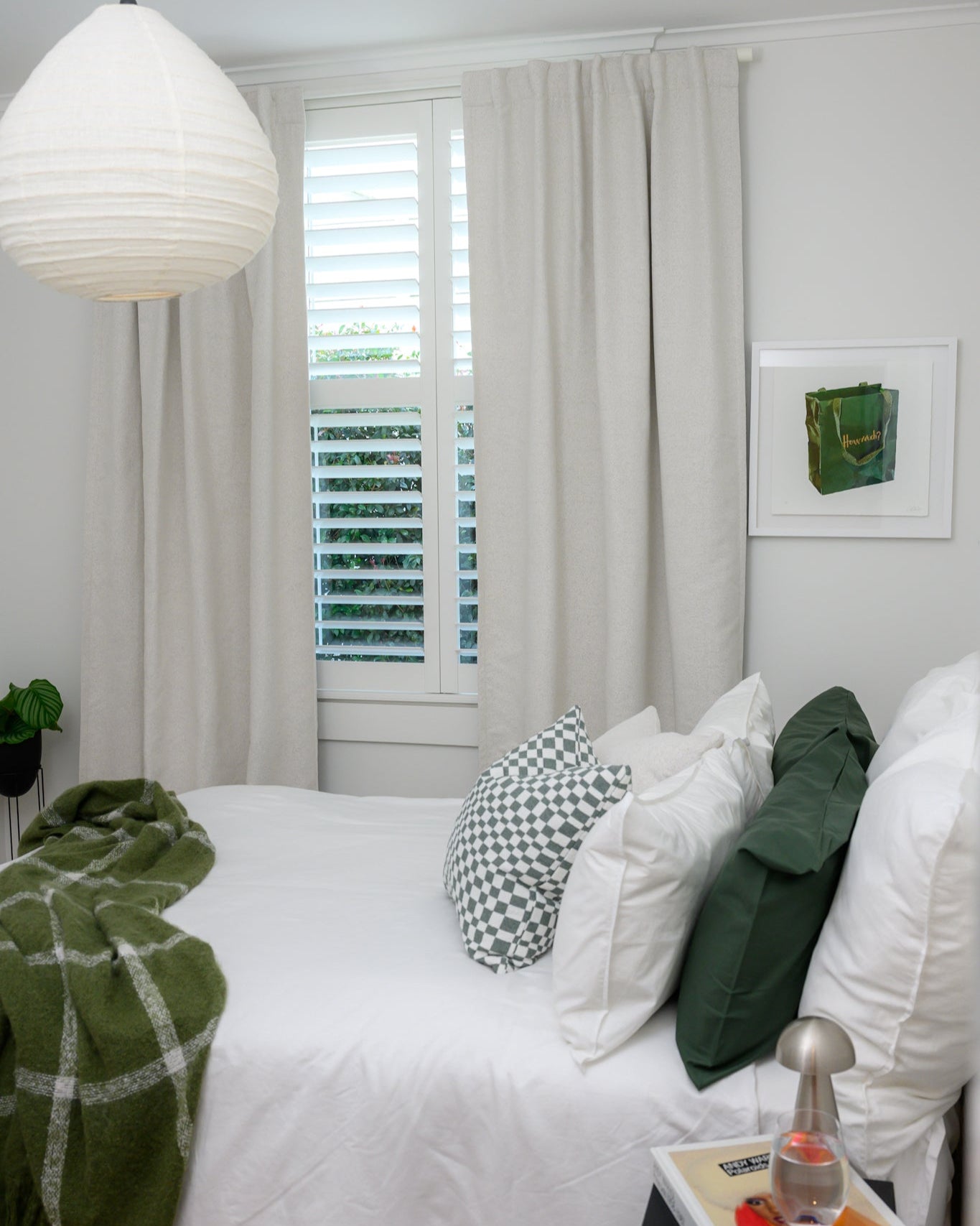 Brooklyn Boucle curtain styled in a bedroom with sage accents, featuring Chicago Check cushion in Sage and Brooklyn Boucle cushions for a cool, modern look.