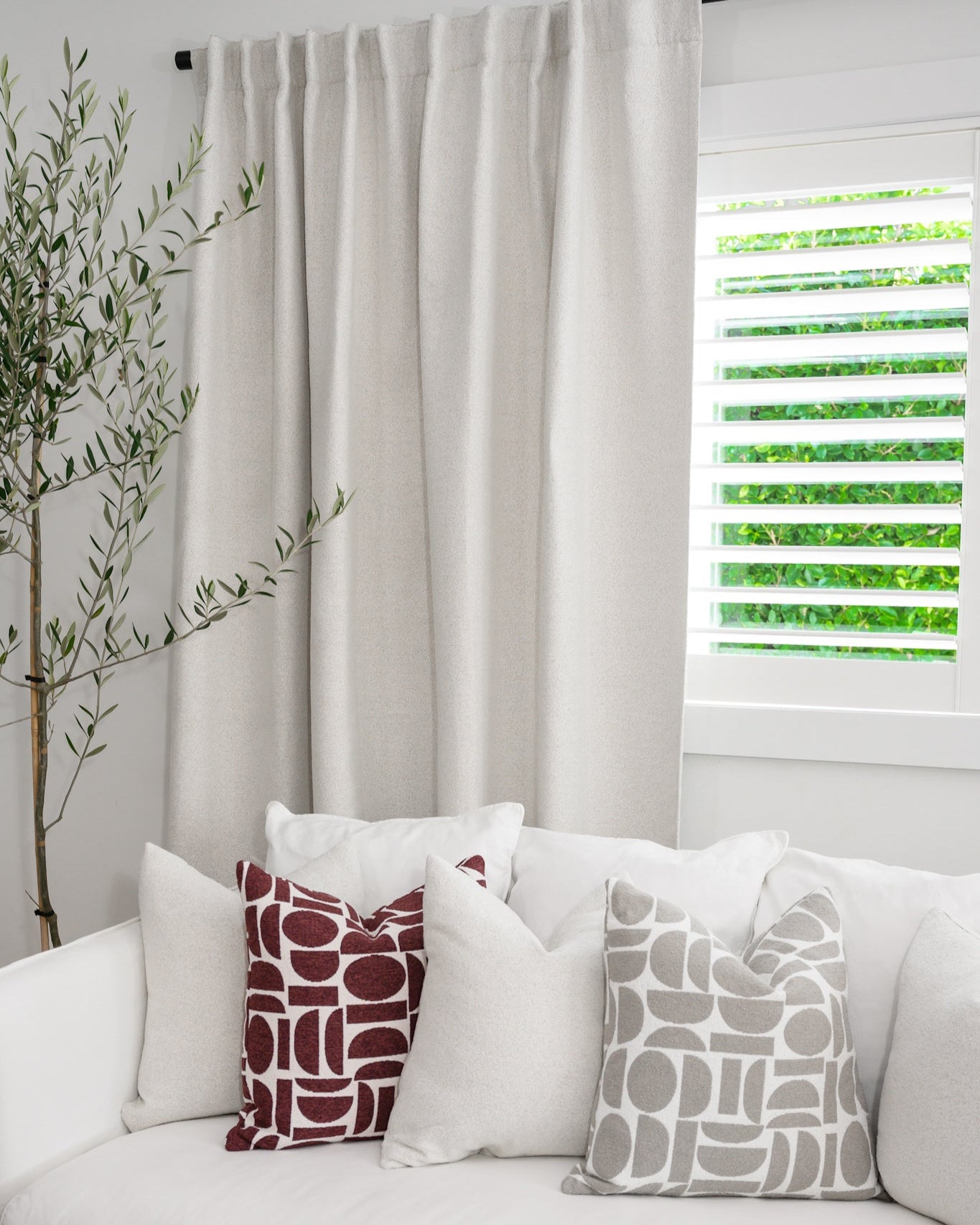 Chelsea Crescent cushions in burgundy and dove grey styled with a Brooklyn Boucle cushion, creating a cohesive designer look.