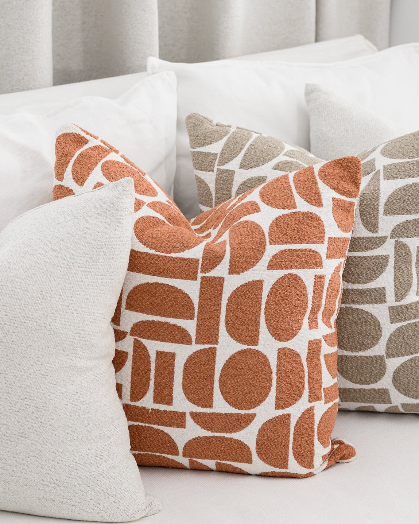 Chelsea Crescent cushions in terracotta and taupe styled with a Brooklyn Boucle cushion, creating a cohesive designer look.