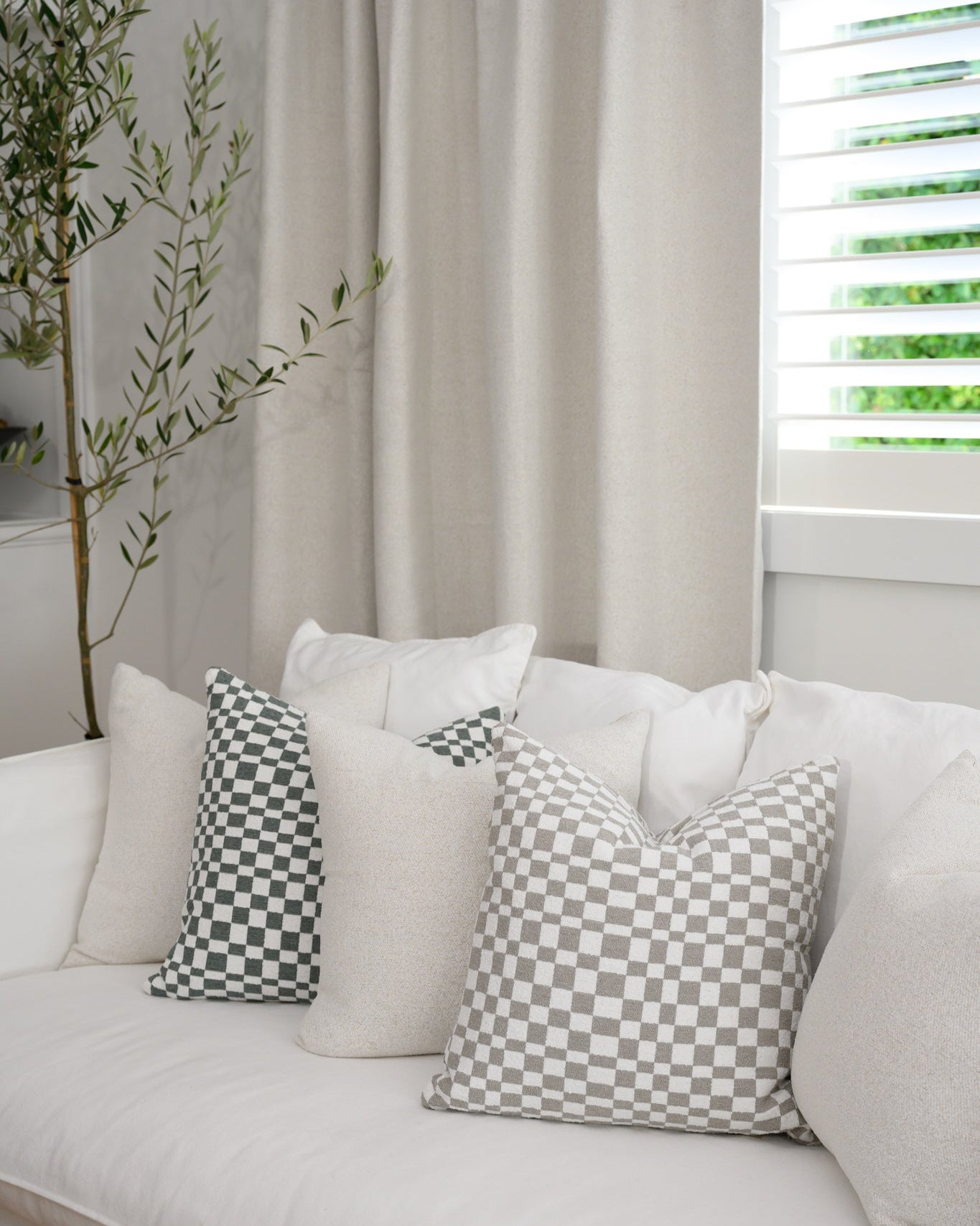 Chicago Check cushions in sage and dove grey styled with Brooklyn Boucle cushions, creating a cohesive designer look.
