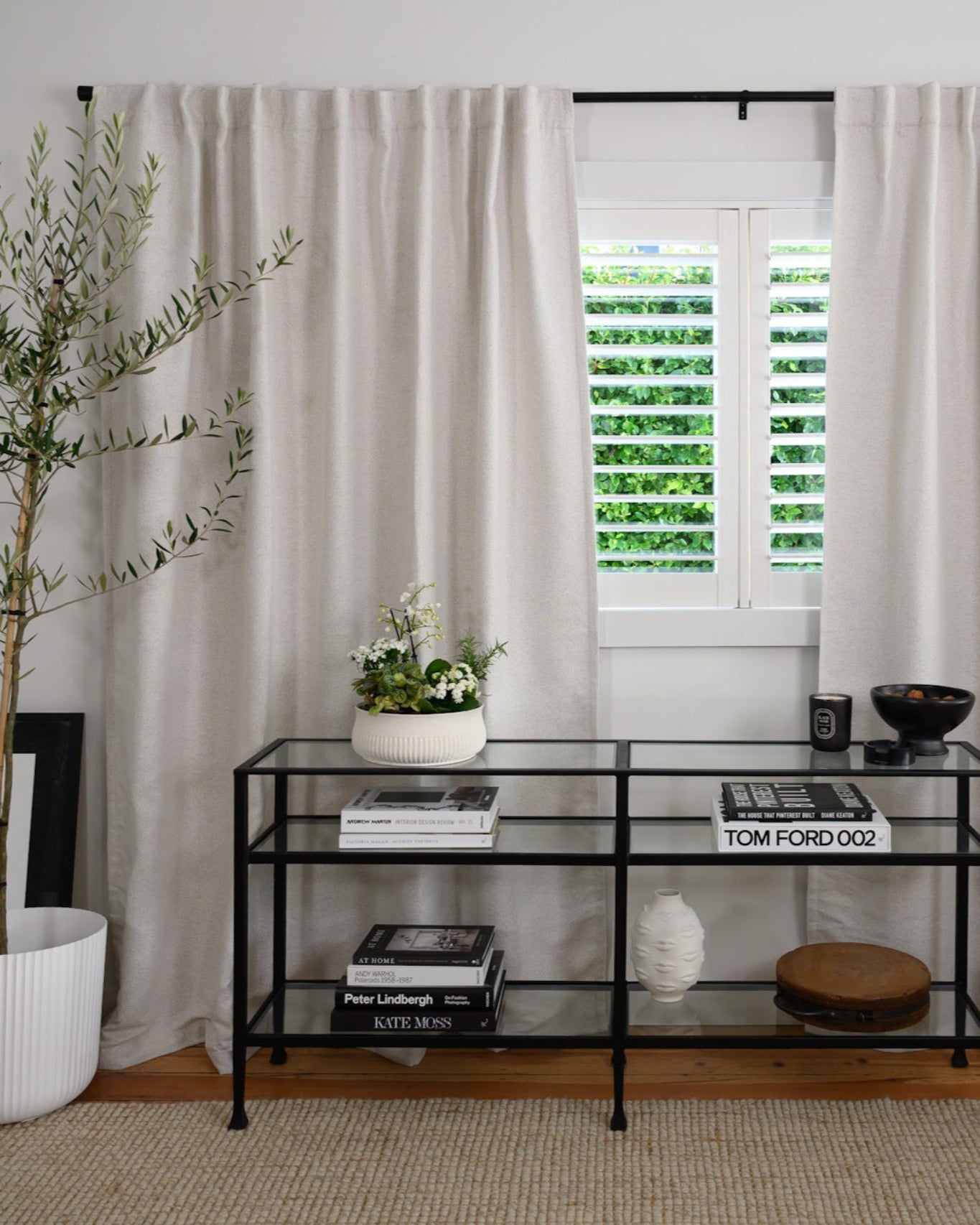 Living room styled with the Rockford Rod in black, perfectly coordinating with a black console for a cohesive, modern look.