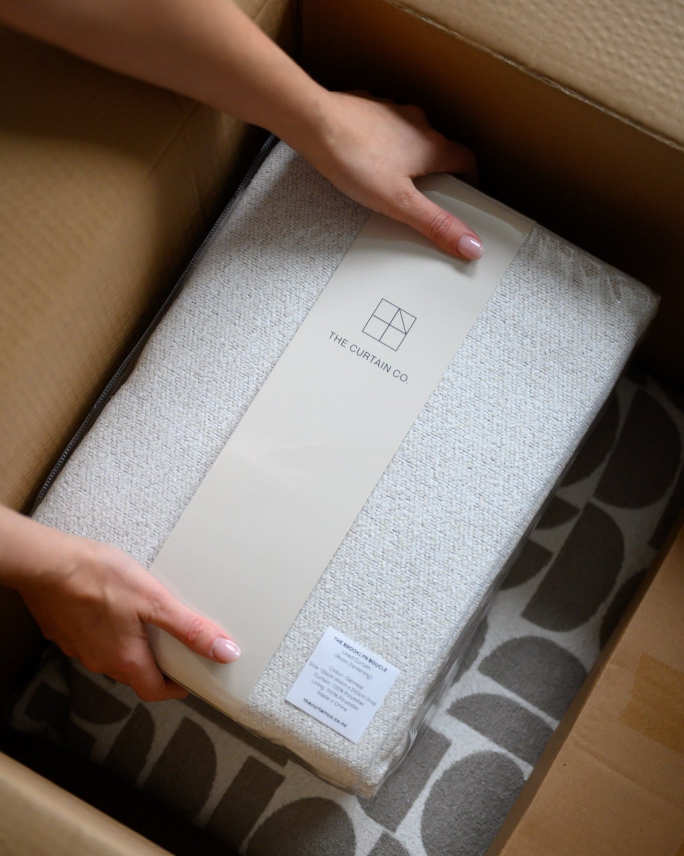 Customer unpacking a Curtain Co order at home, showing fast, easy delivery and beautifully packaged curtains.