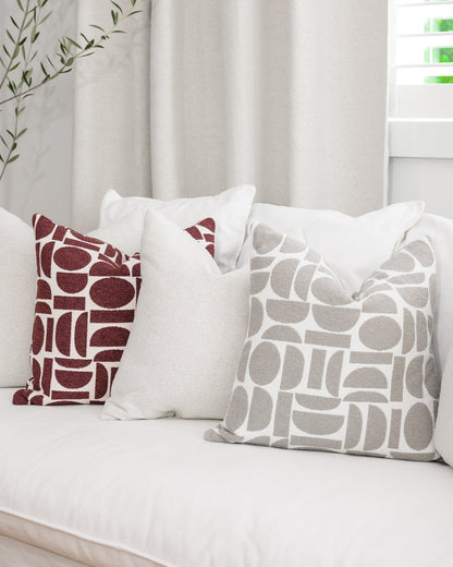 Chelsea Crescent cushions in burgundy and dove grey styled with a Brooklyn Boucle cushion, creating a cohesive designer look.