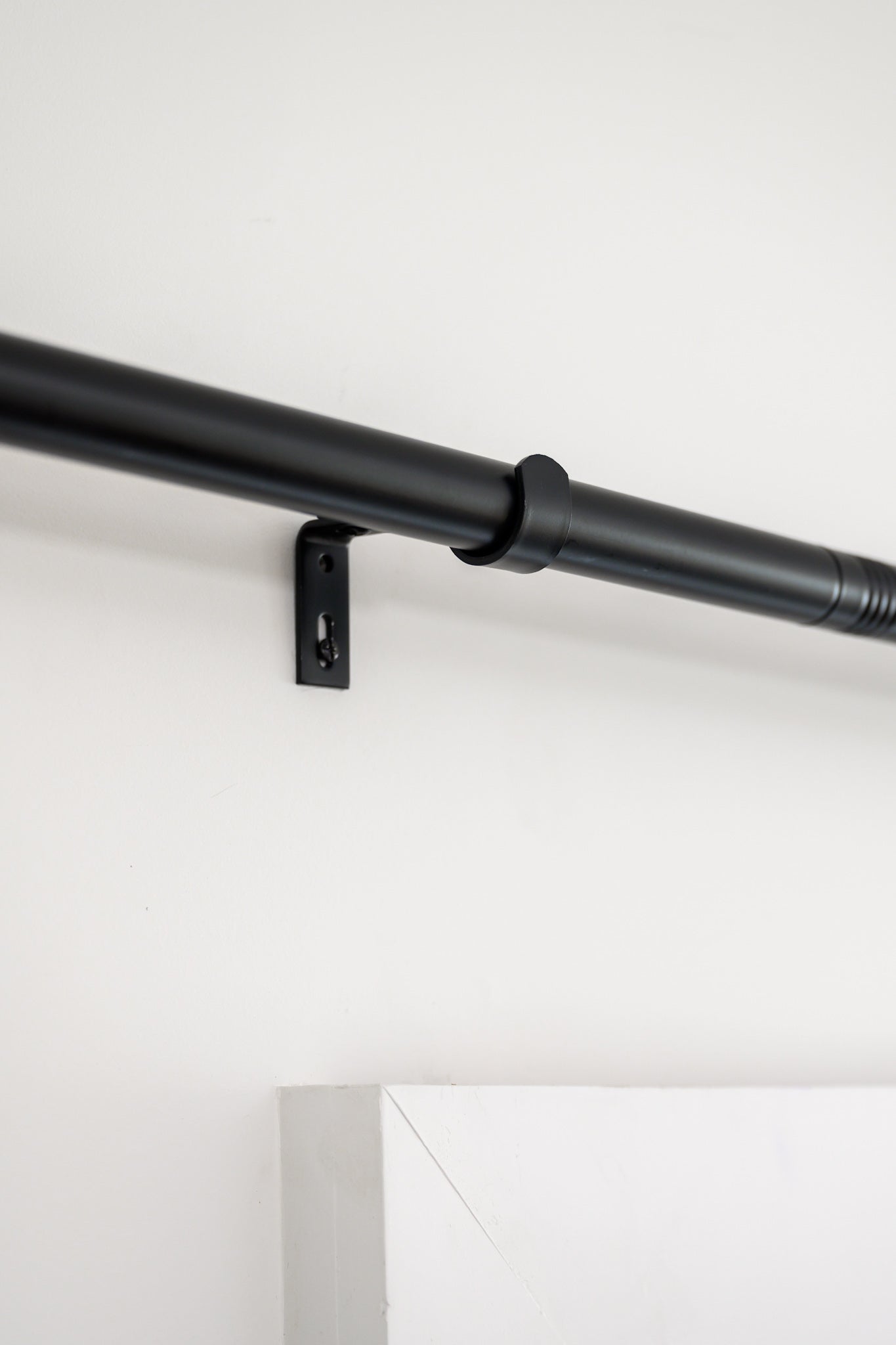 Close-up of Rockford Rod in black, showing the sturdy wall brackets and sleek designer hardware.
