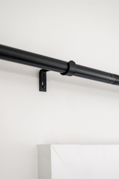 Close-up of Rockford Rod in black, showing the sturdy wall brackets and sleek designer hardware.