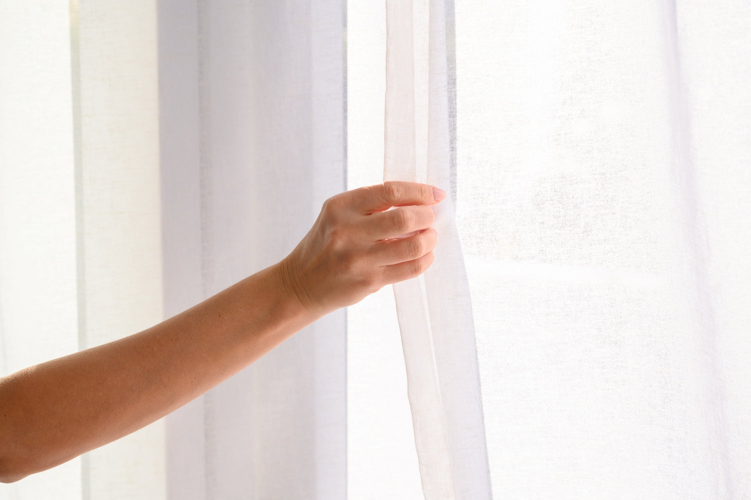 Beautiful close-up of the Soho Sheer curtain in a natural linen blend, being opened to reveal its soft texture and airy drape.