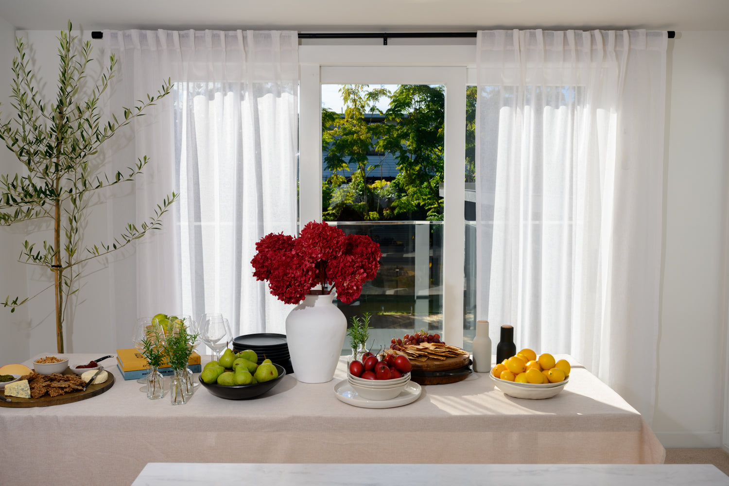 The Soho Sheer curtains styled in a dining room with a chic, modern table setting — the perfect backdrop for relaxed, stylish entertaining.